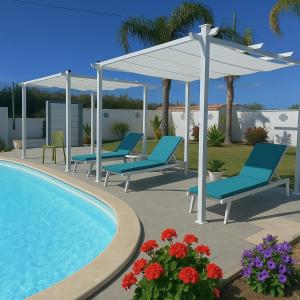 a patio with blue chairs and a swimming pool at Residence Nonna Mariuccia in Mazara del Vallo