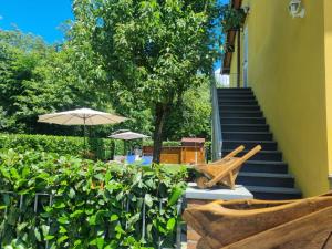 a patio with an umbrella and a chair and stairs at Casa La Pace in Barga