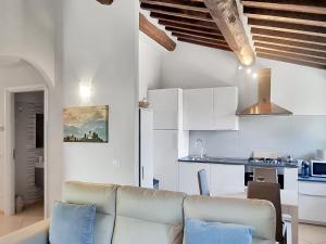 a living room with a couch and a kitchen at Casa La Pace in Barga