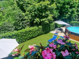 a garden with a pool and some pink flowers at Casa La Pace in Barga