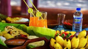 a table topped with a plate of food and fruit at Paddy view cabana sigiriya in Sigiriya