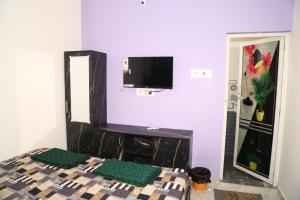 a bedroom with a mirror and a tv on the wall at GK RESIDENCY in Tiruvidaimarudūr