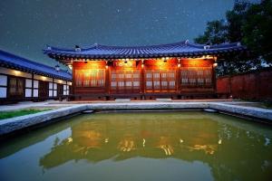 全州市にあるJeonju Hanok Maeul Dongrakwon Hanok Hotelの夜の水たまりのあるアジアの建物