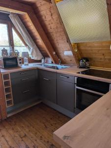 a kitchen with a stove and a sink in a cabin at Ferienhaus Brungers in Südbrookmerland +14 photos