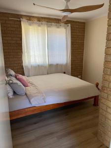 a bedroom with a large bed with a window at BackersBeach Villa in Geraldton +8 photos
