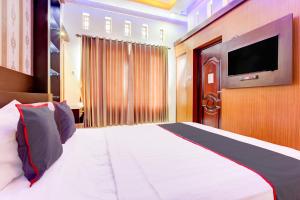 a bedroom with a large bed and a flat screen tv at Hotel O Yogyakarta near MM UGM formerly Bama Guesthouse in Yogyakarta
