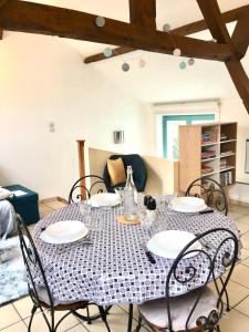 a dining room table with chairs and a table cloth at L'Escapade - Maison 2 chambres - Wissant - Terre des 2 Caps in Wissant