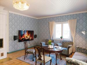 a living room with a table and a fireplace at Villa Metsänvartija in Vihtijärvi