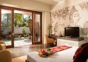 a living room with a table and a television at Taj Bekal Resort & Spa, Kerala in Bekal