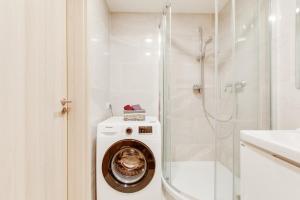a washing machine in a bathroom with a shower at Brand-new, equipped studio near the metro in Prague