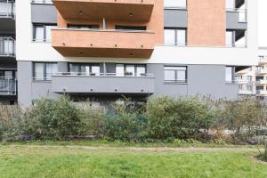 an apartment building with a grass field in front of it at Brand-new, equipped studio near the metro in Prague