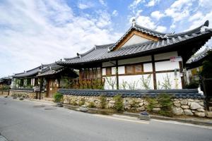 un edificio de estilo asiático al lado de una calle en Jeonju Hanok Ihwa Gotaek Banchayougi Josik, en Jeonju