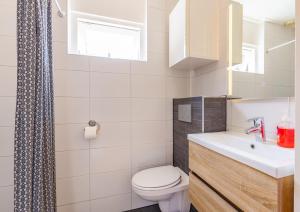 a white bathroom with a toilet and a sink at Daisy-Rose aan de Jan Tooropstraat in Domburg +13 photos