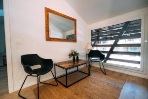 a room with two chairs and a table and a mirror at Lakeside Barn Apartment near Interlaken in Bönigen