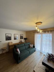 a living room with a green couch and a window at Midori T3 77 m2 in Vars