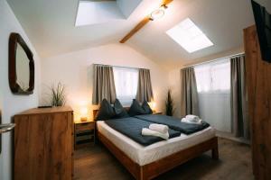 a bedroom with a bed with blue sheets and windows at Lakeside Barn Apartment near Interlaken in Bönigen