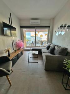 a living room with a couch and a table at SUNRISE SEA VIEW SUITE by Eden in Paralia Katerinis