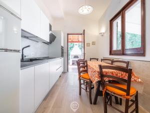 a kitchen and dining room with a table and chairs at Estay - Seaside Gem Villa in Torre delle Stelle +50 photos