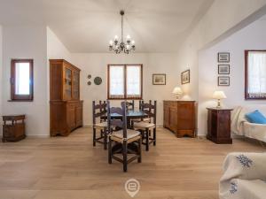 a dining room with a table and chairs and a bedroom at Estay - Seaside Gem Villa in Torre delle Stelle