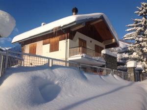 a building covered in snow with a pile of snow at B&B del Villaggio in Argentera