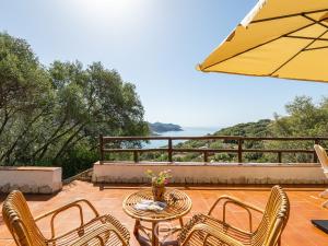 a patio with a table and chairs and an umbrella at Estay - Seaside Gem Villa in Torre delle Stelle