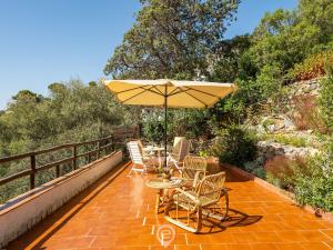 a patio with a table and chairs and an umbrella at Estay - Seaside Gem Villa in Torre delle Stelle