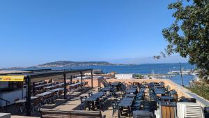 eine Reihe von Tischen und Stühlen am Strand in der Unterkunft Grande Maison avec piscine, parking et wifi in Balaruc-les-Bains