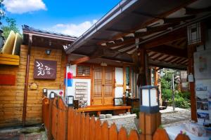 a wooden house with a fence and a gate at Jeonju Kkotjam Pension in Jeonju