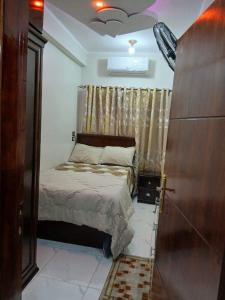a small bedroom with a bed and a window at Al Fahad building in Luxor
