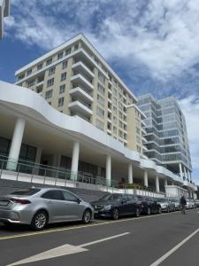 a large building with cars parked in front of it at Central Park 7 in Burgas City