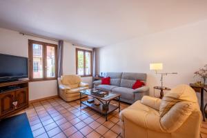 ein Wohnzimmer mit Sofas und einem Flachbildfernseher in der Unterkunft La Maison Marie Andre in Albens