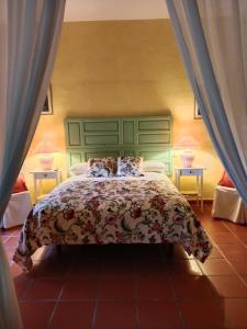 a bedroom with a bed with a green headboard at Hotel Rural El Vaqueril in Navas del Madroño +107 photos