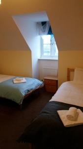 een hotelkamer met 2 bedden en een raam bij Livingston Ideal commuter House in Livingston