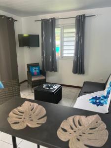 a living room with a couch and a table at Fare Heana- Beau bungalow Moorea in Moorea