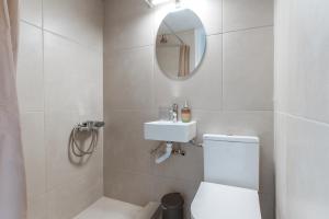 a bathroom with a toilet and a sink and a mirror at Stenies Little Nook in Steniaí