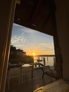 a view of a dock with chairs and a sunset at Sydney Harbourfront Boathouse and Studio Escape in Sydney +7 photos