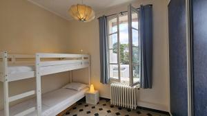ein Zimmer mit zwei Etagenbetten und einem Fenster in der Unterkunft Grande Maison avec piscine, parking et wifi in Balaruc-les-Bains + 63 Fotos