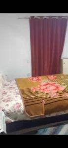 a bed with pink flowers on it next to a curtain at شقة مفروشة فري in Cairo