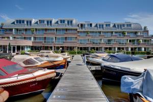 un grupo de barcos atracados frente a un edificio en Kaag Resort en Warmond