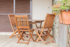 two wooden chairs and a wooden table on a patio at Casa Alessia , il tuo angolo di pace a Nisporto in Nisporto