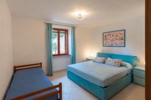 a bedroom with two beds and a window at Casa Alessia , il tuo angolo di pace a Nisporto in Nisporto