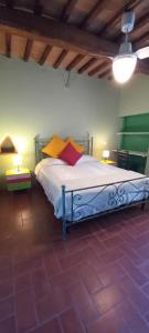 a bedroom with a bed with colorful pillows on it at 2girasoli piano terra in Pucciarelli