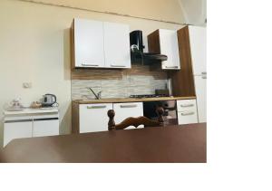 a kitchen with white cabinets and a counter top at Casa in centro a Giarre in Giarre +8 photos