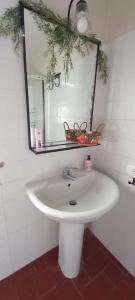 a white sink in a bathroom with a mirror at 2girasoli piano terra in Pucciarelli