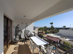 Un balcón con mesa y sillas y una vista en Othello Apartment with Pool, Balcony, Rooftop Hut Tub & 800 m to sandy beach on foot, en Pafos