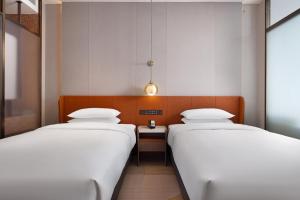 Postel nebo postele na pokoji v ubytování Home2 Suite by Hilton Ningbo Yinzhou
