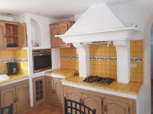 a kitchen with wooden cabinets and a white hood at Dar 'Villa Blanche' in Djerba