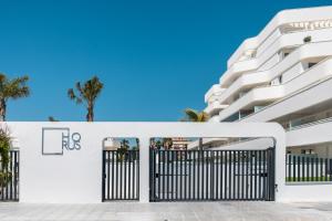 a white building with a gate and palm trees at Horus 051 in Torre del Mar