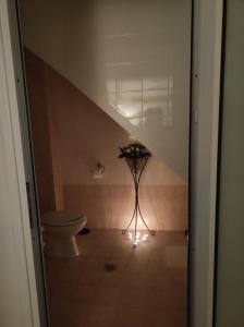 a bathroom with a toilet in a room with an attic at Basement Suite in Tríkala