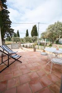 a patio with chairs and a table and a table and chairs at La Bastide des Oliviers in Le Beausset